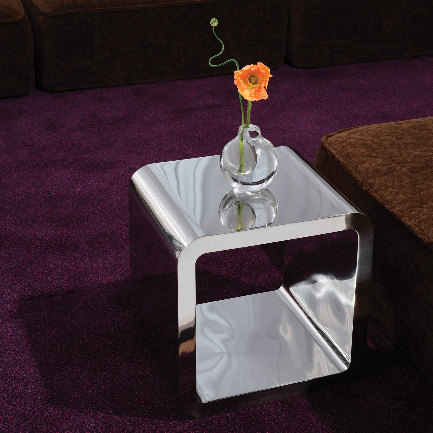 Square mercury table in a living room with a flower on top